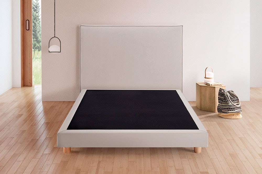 Dormitorio minimalista con una cama moderna de perfil bajo, decoración sencilla y detalles en Bancada Cocoa KHAMA.