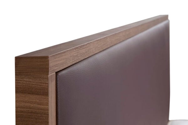 Detalle de una silla moderna con estructura de madera y cabecero modelo Kiara tapizado en piel color marrón suave.
