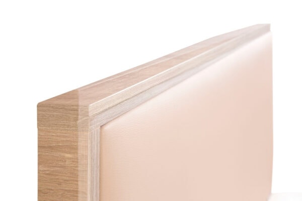Detalle de Cabecero laminado modelo Kiara Borde de madera suave con superficie beige.