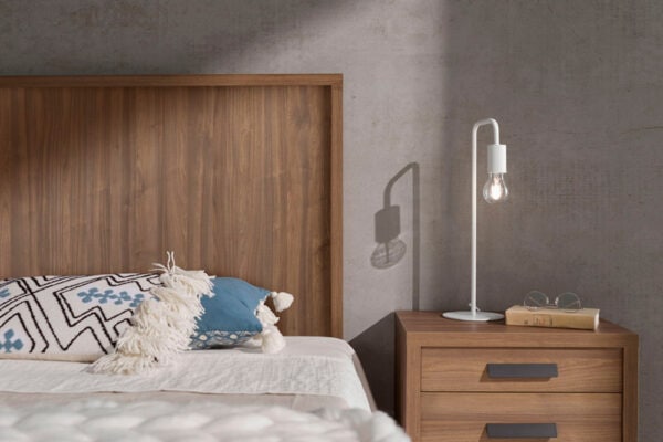 Dormitorio moderno con cabecero de madera modelo Kiara, mesita de noche con lámpara y cojines decorativos.