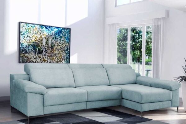 Un Sofá modelo Atenas azul claro en una sala de estar luminosa con un gran cuadro abstracto en la pared.