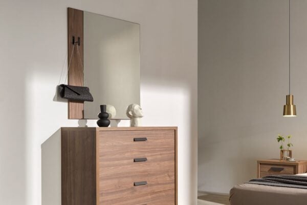 Un dormitorio moderno con una Cómoda Kiara de madera, espejo y elementos decorativos.
