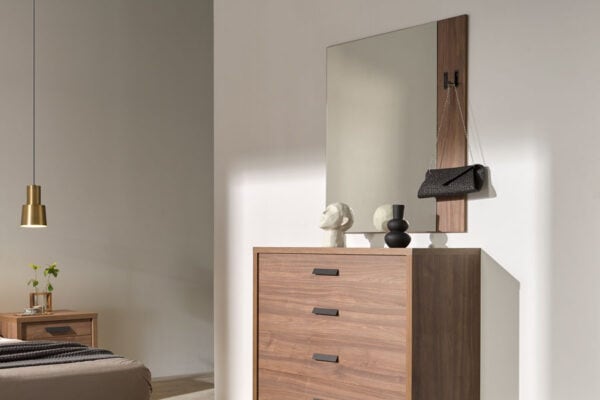Un dormitorio moderno con una cómoda de madera, Espejo Kiara, elementos decorativos y una lámpara colgante.